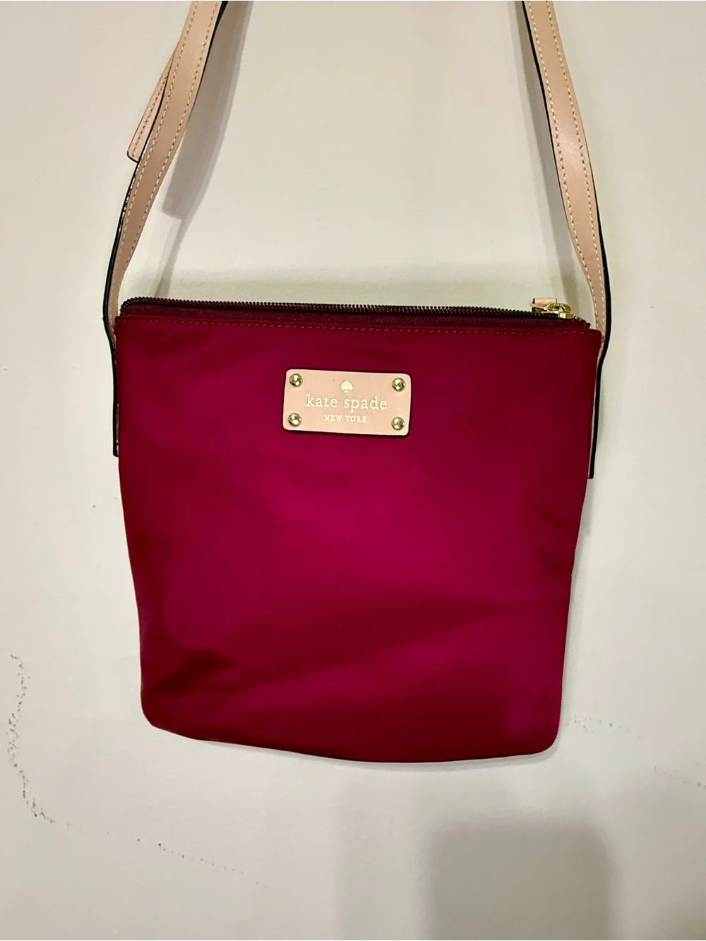 kate spade burgundy crossbody with beige strap and gold plaque